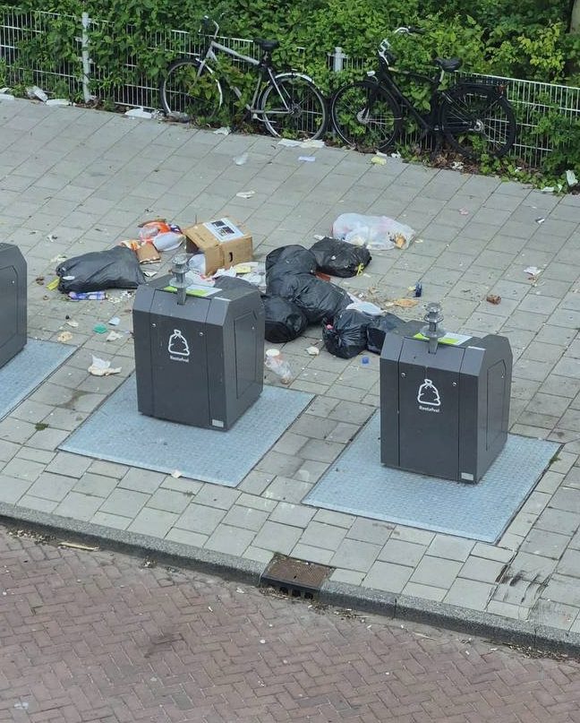 Bijgeplaatst afval rond ondergrondse containers bij groenstrook