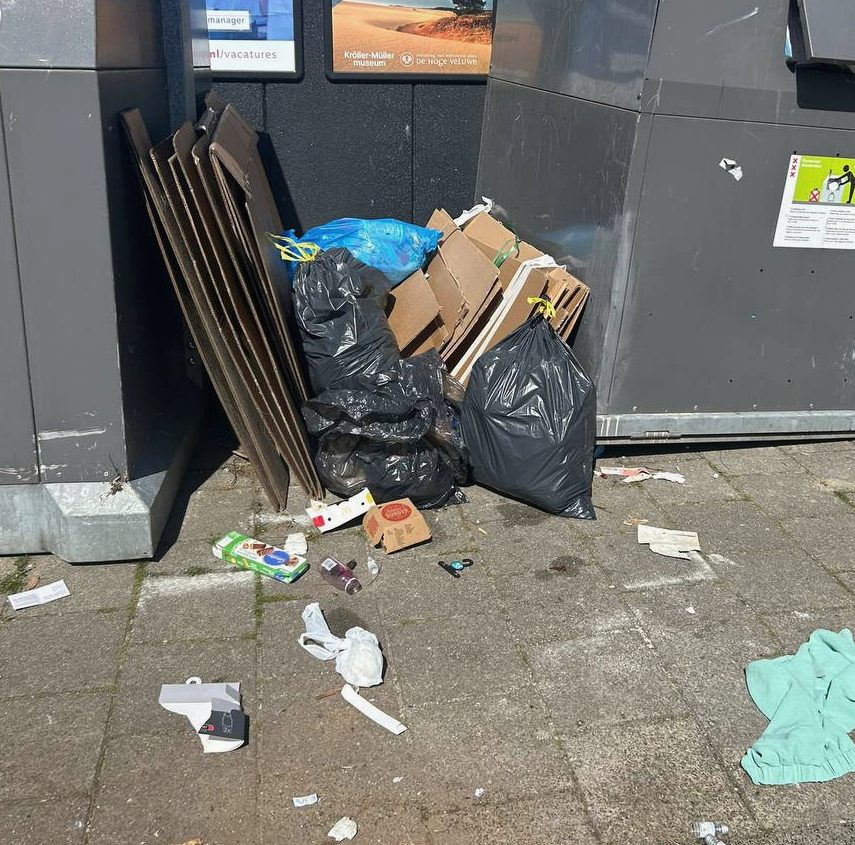 Afval naast ondergrondse containers met karton en vuilniszakken
